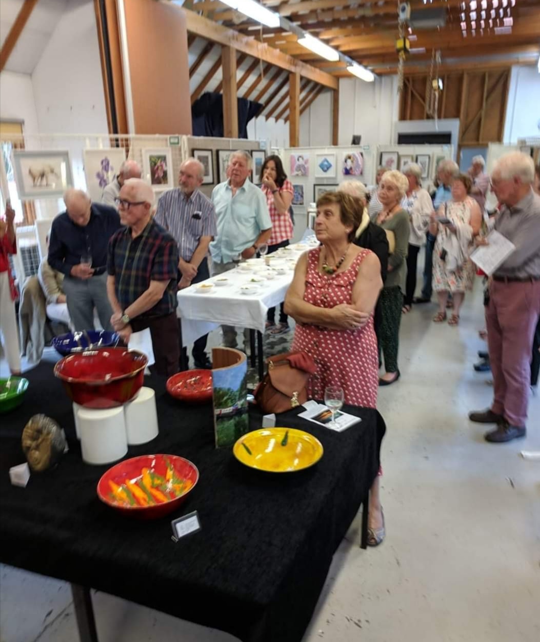 People looking at paintings and objects in an art exhibition